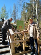 Ari Kantanen asettaa kukat maljaan ja sotilaspoika Paavo Särkkä seuraa toimitusta.
Kuva Lauri Auvinen